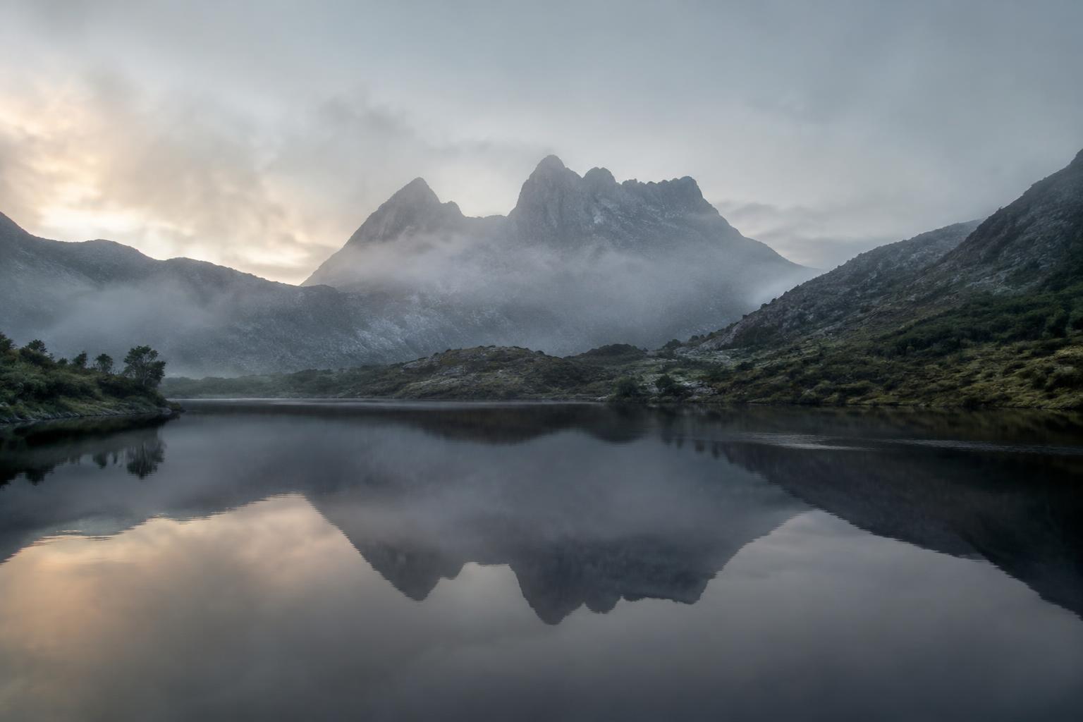 Cradle Mountain reflected in a still lake at dawn
